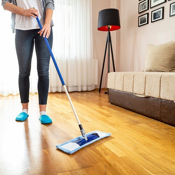 Wiping a floor with a floor wiper | New York Carpets & Flooring